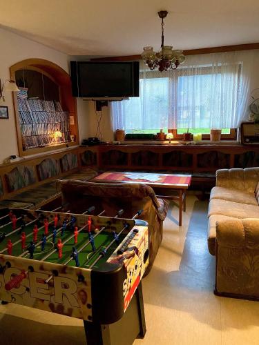 a living room with a pool table in front of a couch at Pension zur Heiligen Krone in Mauterndorf