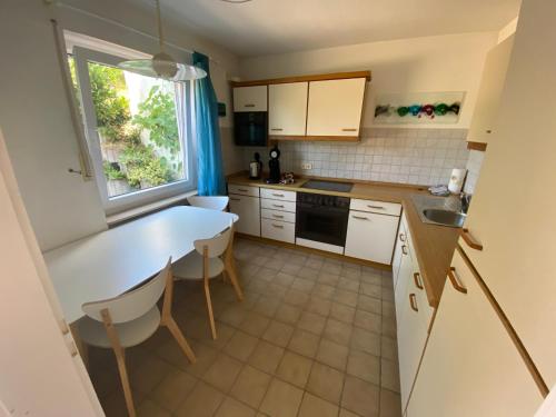 eine kleine Küche mit einem Tisch und einem Fenster in der Unterkunft Ferienwohnung Löwenzahn in Fischingen
