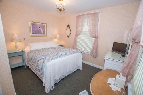 a small bedroom with a bed and a television at Terrace Inn and 1911 Restaurant in Petoskey