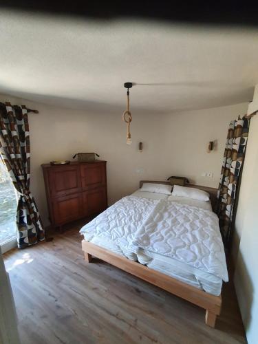 une chambre avec un lit blanc et un parquet dans l'établissement Fischerhaus 1950, au Barcarès
