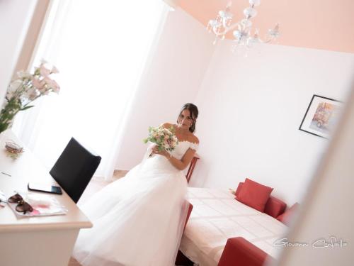 a bride in a hotel room holding a bouquet at Gualtiero Camere & Suite in Caltagirone