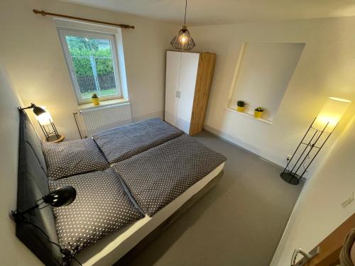 a bedroom with a bed with two lamps and a window at Apartmány U Medvěda in Horní Blatná