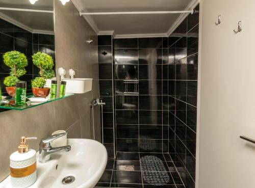 ein Badezimmer mit Waschbecken und Dusche in der Unterkunft DEL MAR APARTMENTS I in Agía Triás
