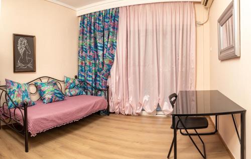 ein Zimmer mit einem Bett und einem Tisch und einem Fenster in der Unterkunft DEL MAR APARTMENTS I in Agía Triás