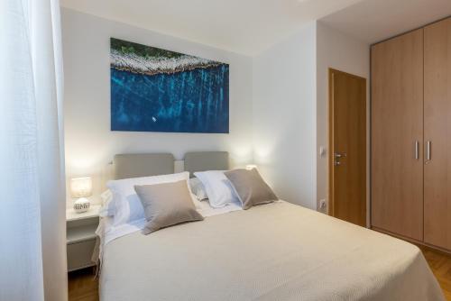蘇佩塔爾的住宿－MAR Sea View Apartment，卧室配有白色的床和墙上的绘画作品