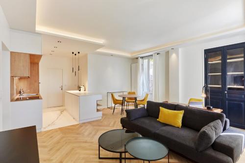 普罗旺斯艾克斯Appartement exceptionnel avec parking Centre-ville Aix-en-Provence的客厅里有一张沙发和一张桌子。