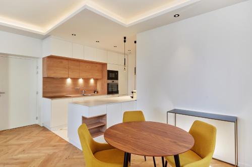 a kitchen with a wooden table and yellow chairs at Appartement exceptionnel avec parking Centre-ville Aix-en-Provence in Aix-en-Provence