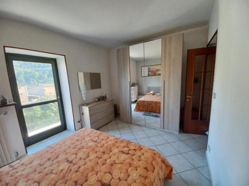 ein Schlafzimmer mit einem Bett und einem großen Fenster in der Unterkunft la Cambuse in Torre Pellice
