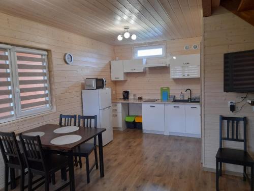 a kitchen with a table and chairs in a room at Malwa Domki Letniskowe in Rusinowo