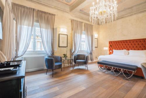 una camera con un grande letto e un lampadario a braccio di Relais Condotta a Firenze