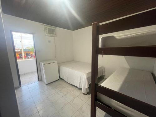 um pequeno quarto com 2 beliches e uma janela em Pousada Allamandas Feliz em Salinópolis