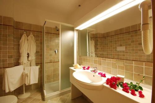 a bathroom with a sink and a mirror and a tub at Hotel Mon Repos in Baja Sardinia