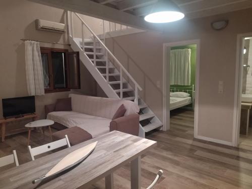 a living room with a couch and a staircase at Theonymfi Luxury Villas in Doukádes