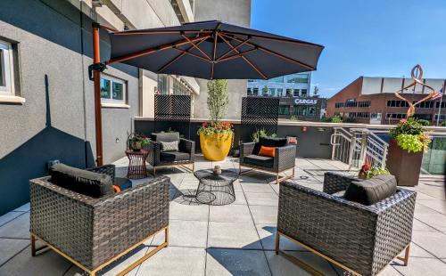 a patio with chairs and an umbrella on a balcony at Holiday Inn Lancaster by IHG in Lancaster