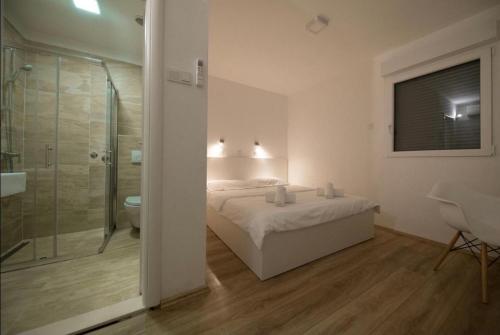a bedroom with a bed and a bathroom with a shower at Sea La Vie Rooms in Novi Vinodolski