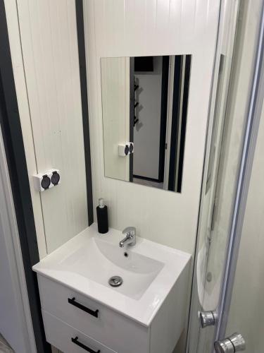 a bathroom with a white sink and a mirror at Domki Kalimera 3 in Jantar