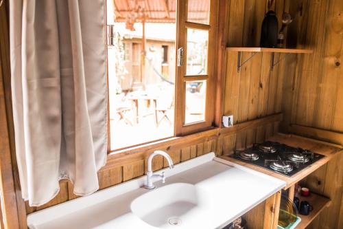 a kitchen with a sink and a window at Villa Rosa Cabanas in Guarda do Embaú