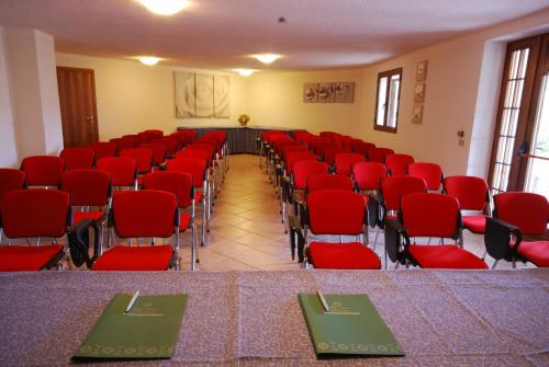 an empty room with red chairs and a table and chairsktop at Hotel Mon Repos in Baja Sardinia