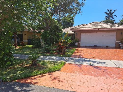 a house with a driveway and a garage at Baynefamilyflorida. in Fort Lauderdale