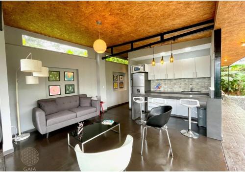 sala de estar con sofá y cocina en Glamping Gaia Origen en Cali - Cabaña y Domo Geodésico a 10 min de los Gatos del Río, en Cali