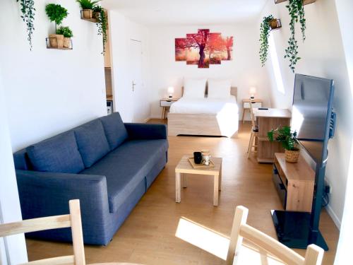 - un salon avec un canapé bleu et un lit dans l'établissement Le Petit Soleil de Corbeil, à Corbeil-Essonnes