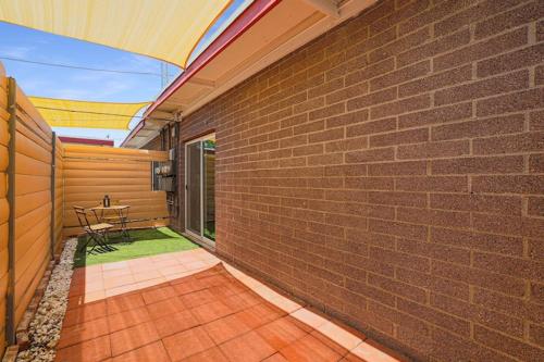 a patio with a table and a brick wall at LaRocco On Turney Biltmore in Phoenix