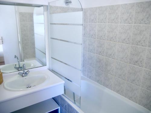 La salle de bains blanche est pourvue d'un lavabo et d'une douche. dans l'établissement Le Petit Soleil de Corbeil, à Corbeil-Essonnes