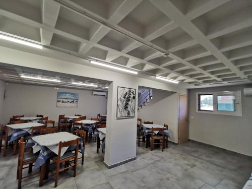 a dining room with tables and chairs and ceilings at 3 Island View Hotel in Nydri