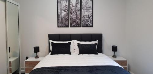 1 dormitorio con 1 cama grande con sábanas blancas y negras en Pioneer Motel, en Palmerston