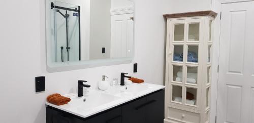 a white bathroom with a sink and a mirror at Pioneer Motel in Palmerston