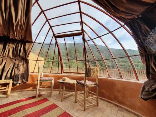 a room with two chairs and a table and a window at Kasbah Africa - High Atlas Dark Sky & Nature Lodge in Ouirgane