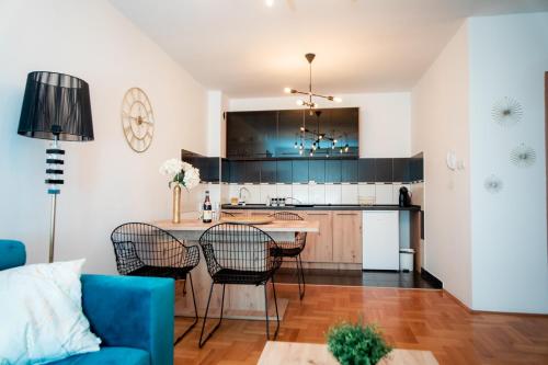 a kitchen and living room with a blue couch at Lux stan na dan Pozarevac in Požarevac