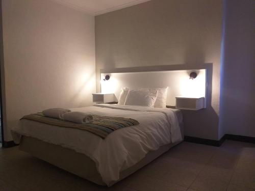 a bedroom with a large bed with two lights on it at San Marco Hotel Curacao & Casino in Willemstad