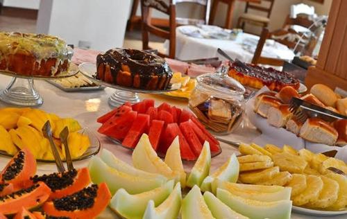 a table with many different types of fruits and desserts at Hotel Nevada Ubatuba in Ubatuba