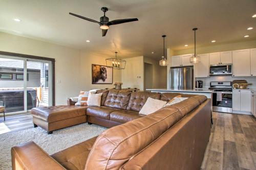a living room with a brown couch and a kitchen at Modern Bozeman Family Townhome with Hot Tub! in Bozeman