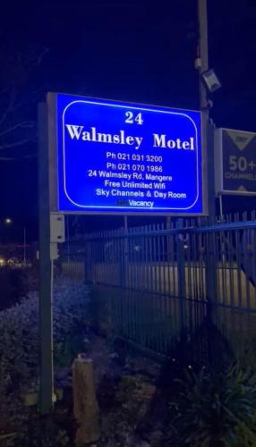 a blue sign for a walleye motel at night at Walmsley Motel Mangere in Auckland