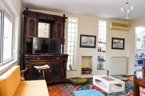 a living room with a large wooden entertainment center with a flat screen tv at Blue Door Hostel in Tirana