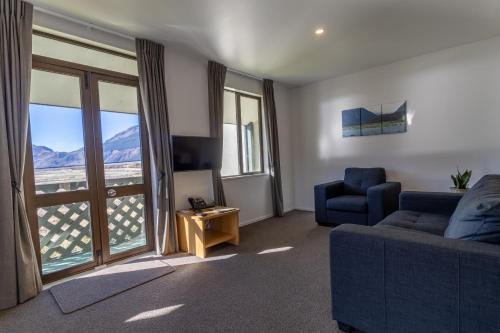 uma sala de estar com um sofá azul e uma janela em The Bealey Hotel em Arthur's Pass