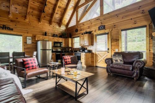 een woonkamer met lederen meubels en een keuken bij Bear Time Cabin - Scenic Mountain View, Firepit, Hot Tub, Theater, 4BR 3BA Sleeps 14 in Sevierville