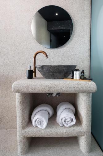 a bathroom sink with towels under a mirror at COCO SUITES in Vasiliki