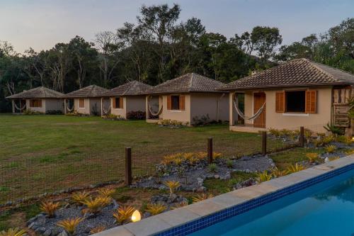 a row of cottages with a swimming pool at Montanhas Do Visconde in Visconde De Maua