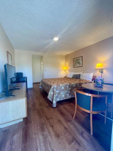LakeportにあるRegency Inn Lakeportのベッドとテーブルとテレビがあるホテルの部屋