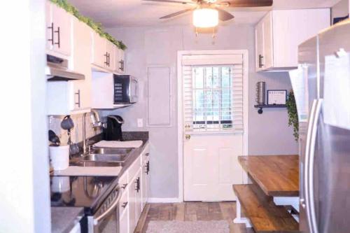 a white kitchen with a sink and a refrigerator at The Green House in Nashville