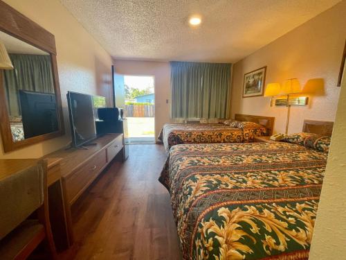 Habitación de hotel con 2 camas y TV de pantalla plana. en Regency Inn Lakeport, en Lakeport