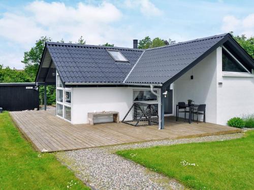 una casa con terraza y techo negro en 6 person holiday home in Struer, en Remmer Strand