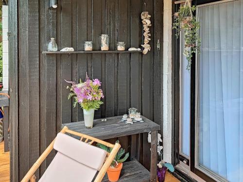 - une table et une chaise sur une terrasse couverte fleurie dans l'établissement 5 person holiday home in Vinderup, à Vinderup