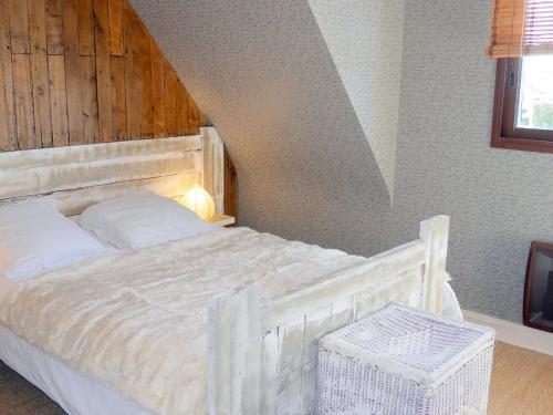 une chambre avec un lit blanc avec une tête de lit en bois dans l'établissement Holiday Home in Guisseny with Jacuzzi & Beach, à Guissény
