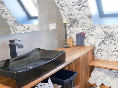 La salle de bains est pourvue d'un lavabo noir et d'un comptoir. dans l'établissement Holiday Home in Guisseny with Jacuzzi & Beach, à Guissény