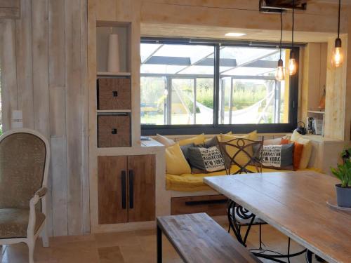 un salon avec un canapé jaune et une table dans l'établissement Holiday Home in Guisseny with Jacuzzi & Beach, à Guissény