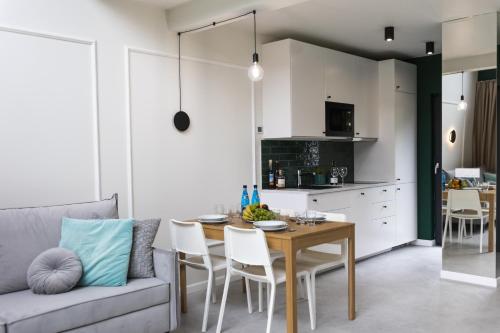 uma sala de estar com uma mesa e um sofá em Mare Boutique Houses em Niechorze